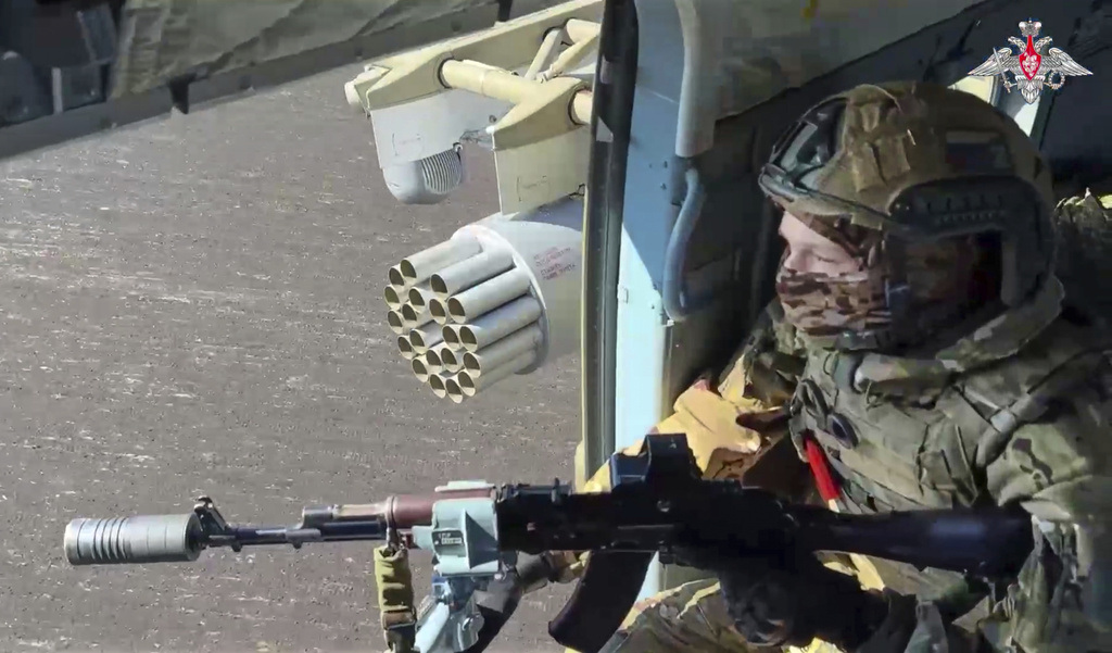 A Russian army soldier patrols from onboard a military helicopter in an undisclosed location in Ukraine.