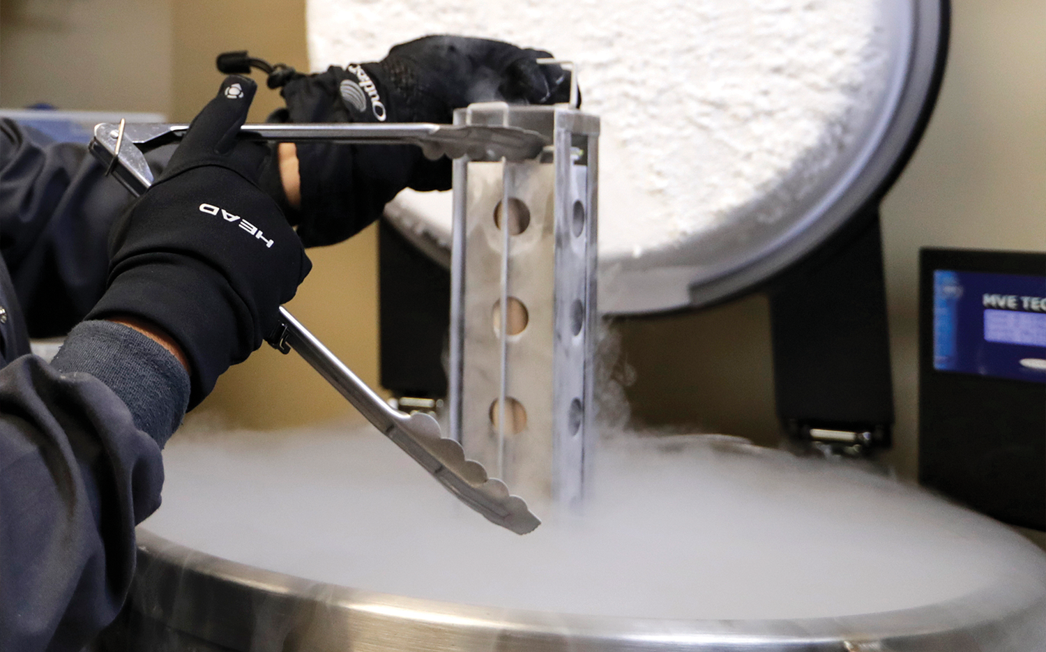 A container with frozen embryos and sperm stored in liquid nitrogen is removed at a fertility clinic.